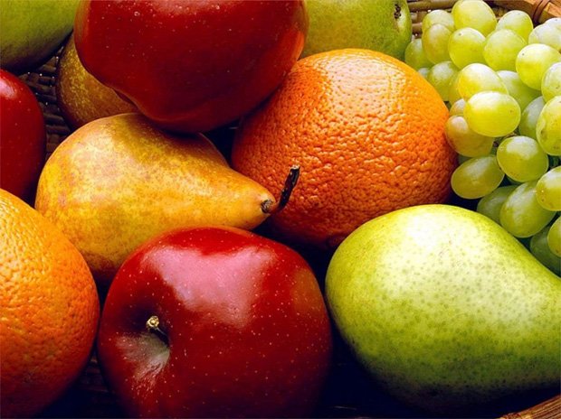На столе лежат яблоки, груши, виноград и апельсины